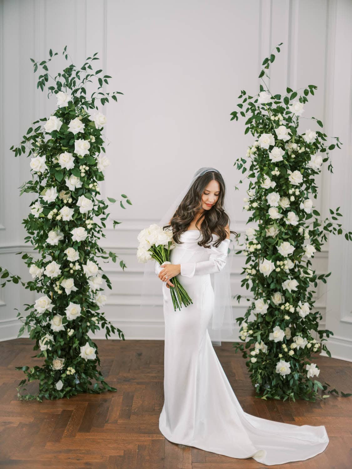Beautiful white wedding flowers arch with lush greenery for wedding decor.