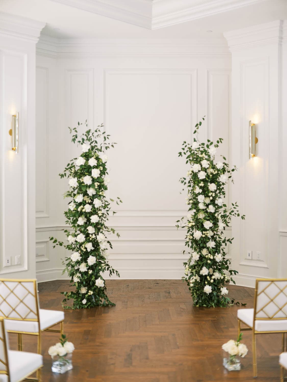 Beautiful white floral wedding arch with greenery for wedding decor.