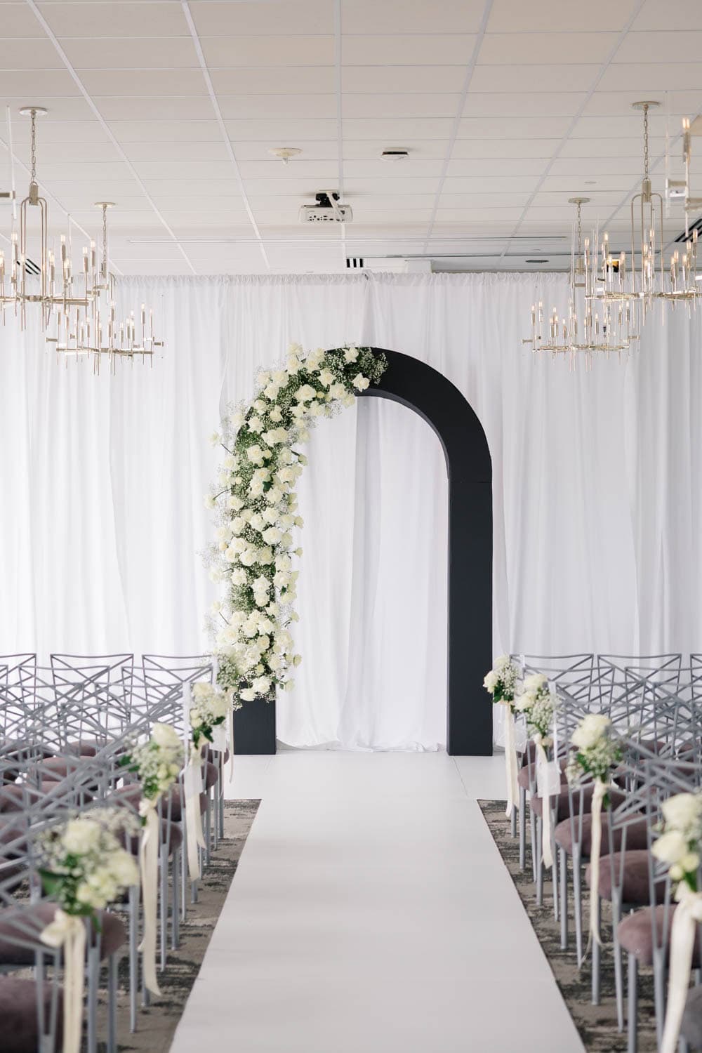 Wedding floral arch with white roses and greenery for special ceremonies.