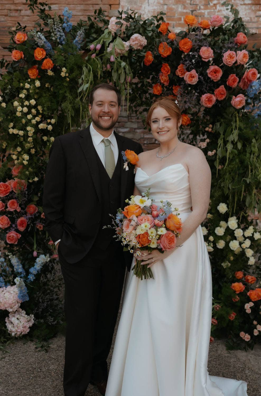 Wedding floral arrangement with vibrant roses and peonies.
