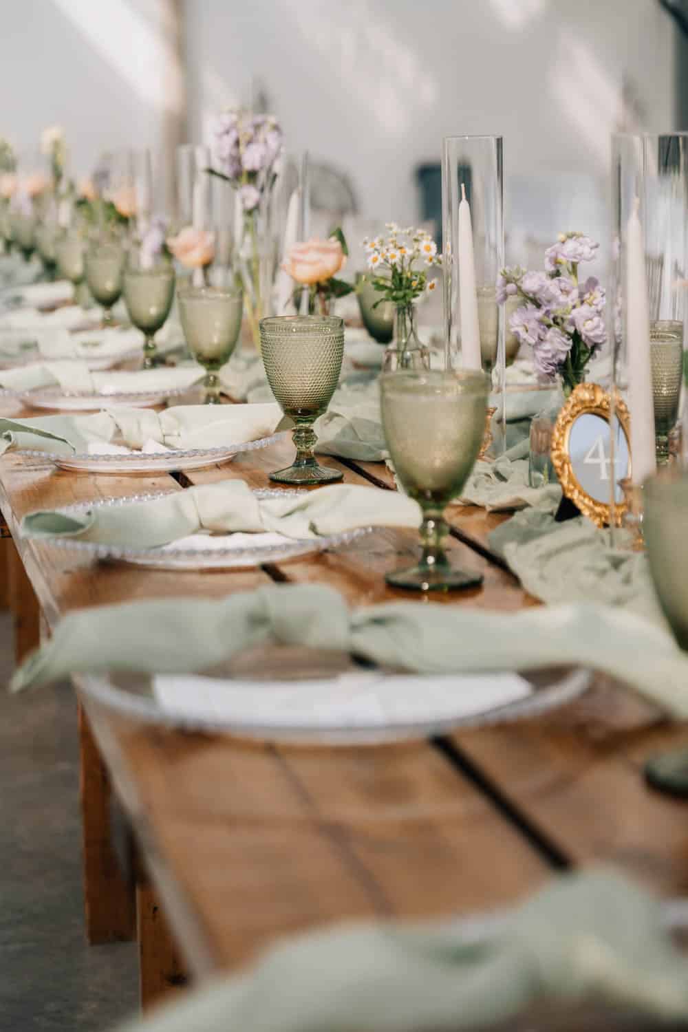 Elegant floral table setting with pastel flowers and candles for weddings or special occasions.