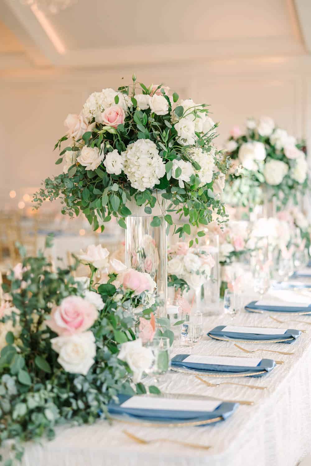 Elegant floral centerpiece with white and pink roses for wedding decor, featuring lush greenery in a.