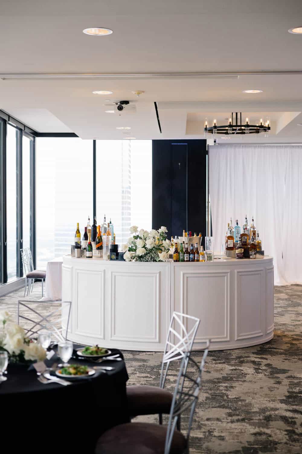 Elegant flower bar setup with floral arrangements and beverages at Simply Blessed Flowers event.